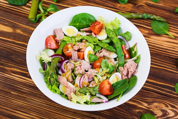 Ton balığı, domates, bıldırcın yumurtası, kuşkonmaz ve ahşap zemin üzerine soğan salatası