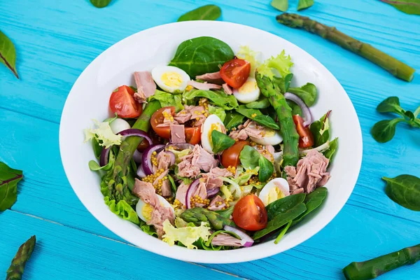 Ton balığı, domates, bıldırcın yumurtası, kuşkonmaz ve ahşap zemin üzerine soğan salatası