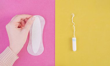 Hijyen bakımı sırasında kritik gün. Bir tampon ve sıhhi bir yastık arasında seçim yapma. Adet döngüsü. Kadın bir hijyenik ped elinde tutar. Üstten Görünüm