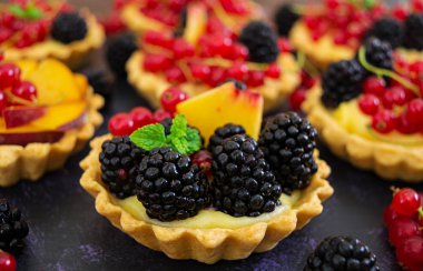 Tartlets koyu arka plan üzerinde farklı çilek ile