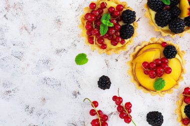 Beyaz arka plan üzerinde farklı meyveleri ile tartlets. Üstten Görünüm