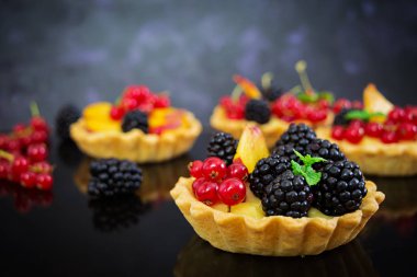 Tartlets koyu arka plan üzerinde farklı çilek ile