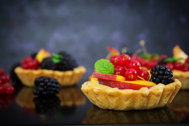 Tartlets koyu arka plan üzerinde farklı çilek ile