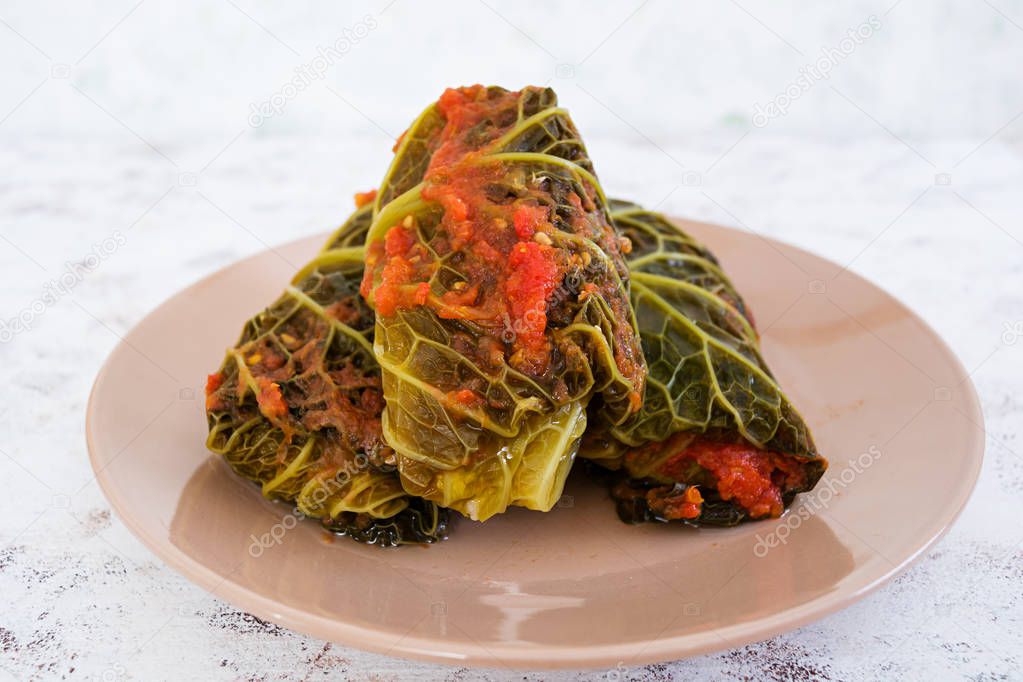 Cabbage rolls with savoy leaves on white background