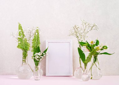 Çiçekler ve bitkiler çerçeve ile şişede. Vazo çiçekleri ile güzel bahar arka plan.