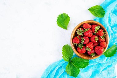 Beyaz ahşap arka planda izole edilmiş taze olgun çilek..