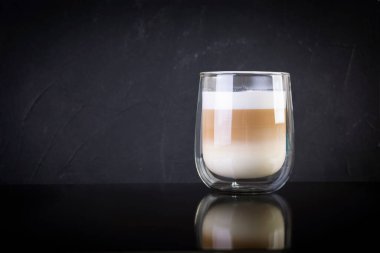 Bir fincan kahve macchiato. Koyu arka planda sıcak içecek kahvesi