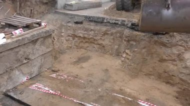 Tekerlek kazıcısı çalışıyor. Bir kova ile donatılmış..