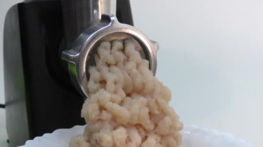 Elektrikli et öğütücüsü kullanarak tavuktan kıyma yapma işlemi..