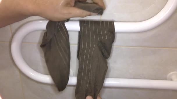 人在干燥的线圈上擦干袜子 — 图库视频影像