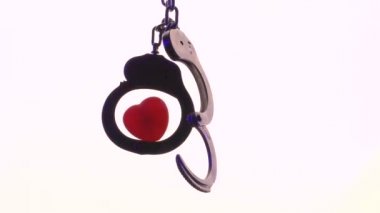 Elleri kelepçeliyken kalp çarpıyor ve soluyor. Emniyet güçlerince kullanılan çelik kelepçeler. Video arka planda çekilmiş..