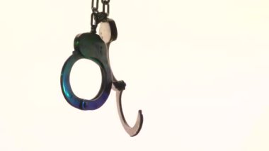 Emniyet güçlerinde ve rol yapma oyunlarında kullanılan çelik kelepçeler. Video arka planda çekilmiş..