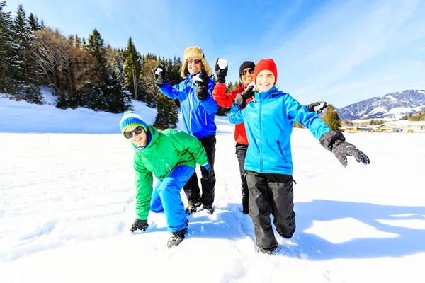 Vierköpfige Familie vergnügt sich im Schnee — Stockfoto