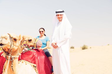 Arap adam ve turistik bir deve sürme