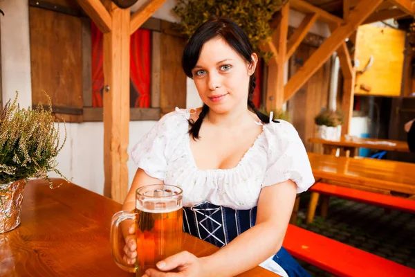 Ung tysk kvinde nyder et krus øl - Stock-foto