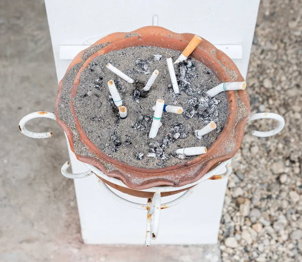 Toprak kül tablası ile sigara saplama yakınındaki beyaz Kutbunda alan.