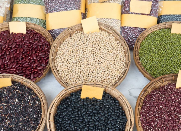 Variety of the organic whole grains in the wooden basket,local market in the countryside of Thailand.