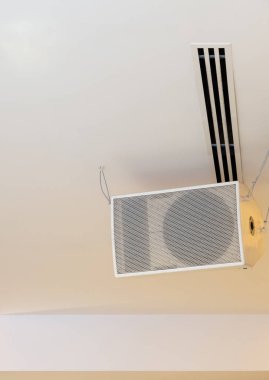Büyük beyaz hoparlör ile metal tel sergi salonu tavandan asılı.