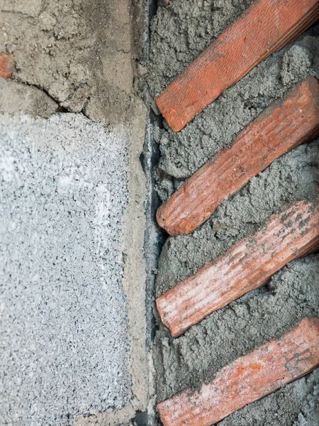 Closeup of the unfinished  brick wall in the under construction of the countryside house.