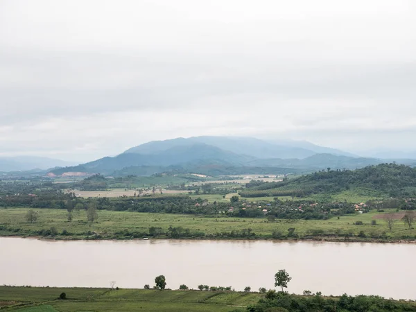 Grande rivière tranquille près de la ferme et du village de campagne . — Photo