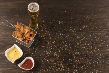 Ketçap moztaza ile Patatoes ve bira rustik masada yukarıdan izlendi