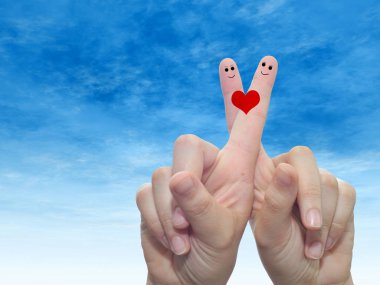 Kavram ya da iki parmak ile kavramsal insan veya kadın el boyalı bir kırmızı kalp ve gülen yüzler bulut mavi gökyüzü arka plan üzerinde