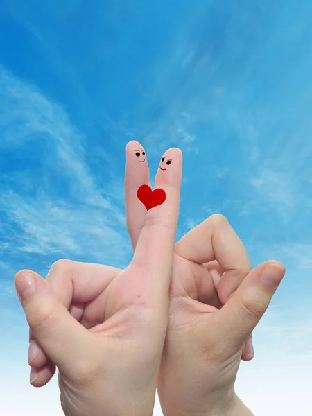 概念的人类或女性手用两个手指涂上红色的心和笑脸云蓝色天空背景下的面孔 — 图库照片