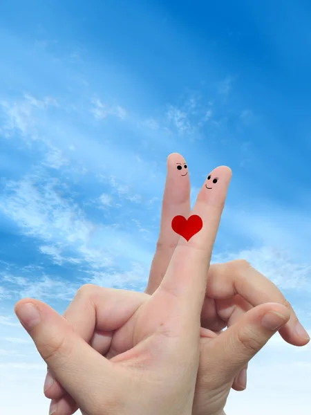 概念的人类或女性手用两个手指涂上红色的心和笑脸云蓝色天空背景下的面孔 — 图库照片