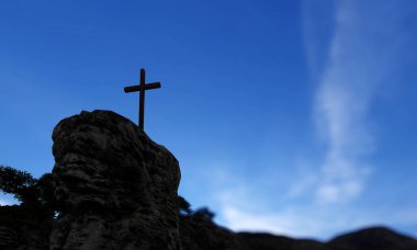 Concept ya da kavramsal dini Hıristiyan çapraz güzel günbatımı gökyüzü üzerinde dağın üzerinde kaya ayakta. İnanç, din inanç, Isa Mesih veya manevi kilise 3D illüstrasyon için bir arka plan