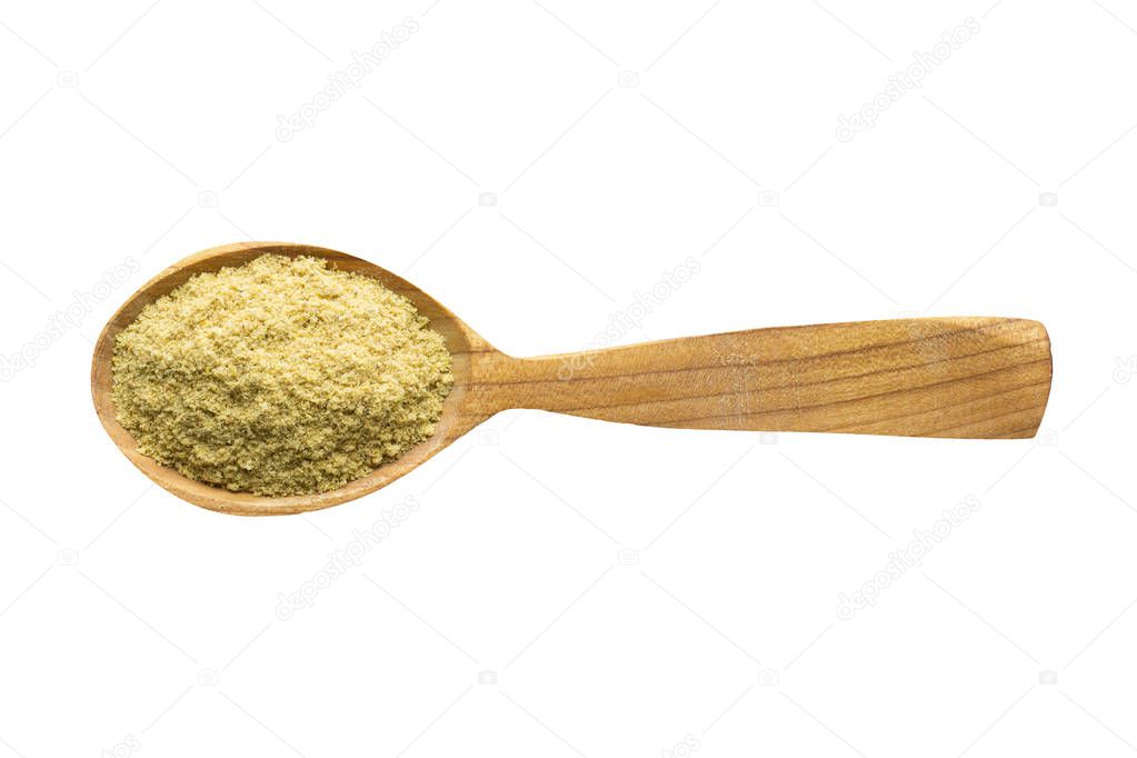 mustard powder for adding to food. spice in wooden spoon isolated on white. seasoning of delicious meal.