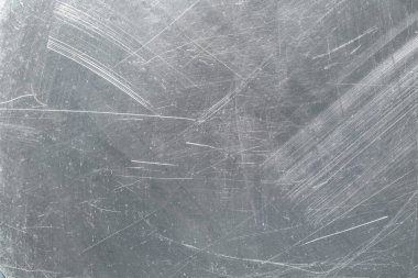 Üzerinde çizikler olan gri demir plaka, krom parlatıcılı metal doku.