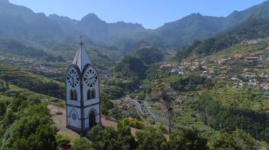 Eski kilise ve dağlık bir manzara içinde bir tepede Saat Kulesi