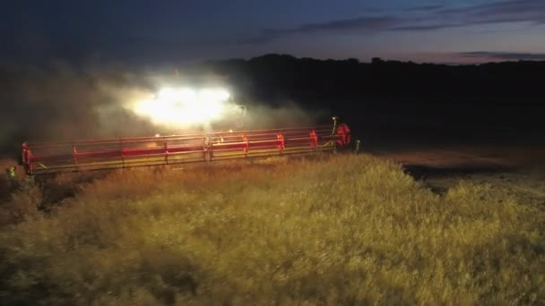 コンバイン刈取収穫菜種フィールドに夜間作業中 — ストック動画