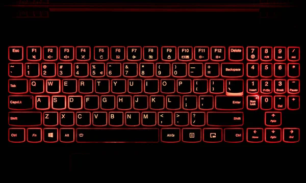 Gaming-Laptop-Tastatur mit roter Hintergrundbeleuchtung im Dunkeln. — Stockfoto
