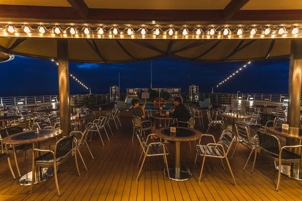 Passagiere entspannen sich am Abend in der offenen Bar des Schiffes — Stockfoto