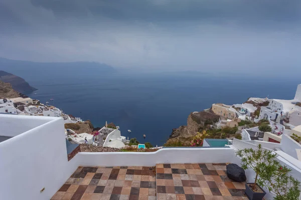 Panorama del pueblo de Oia y la caldera en un raro día lluvioso — Foto de Stock