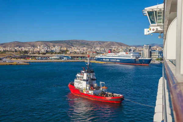 在雅典比雷埃夫斯港与一艘游轮一起工作的拖船 — 图库照片