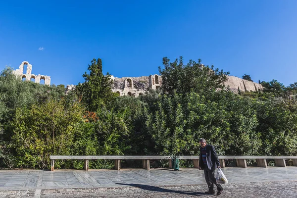 Hombre caminando solo con una bolsa en sus manos al pie de la Acrópolis, Atenas — Foto de Stock