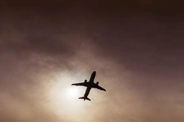 Silhouette d'avion de ligne visible sous une entaille dans les nuages — Photo