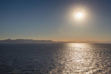 Salamis adası arka plan ile deniz üzerinde batan güneşin Yansımaları