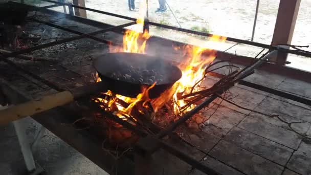 Kaštany vařené s charakteristickým pánvičem nad žhavými uhlíky — Stock video