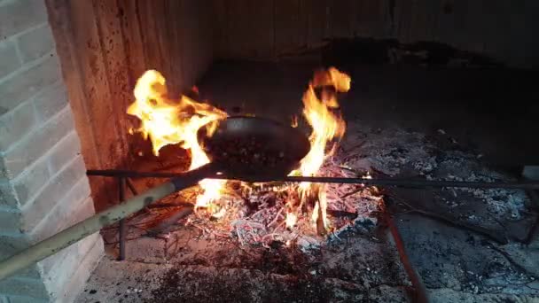 Chestnuts cooked with a characteristic pan over hot embers — Stock Video