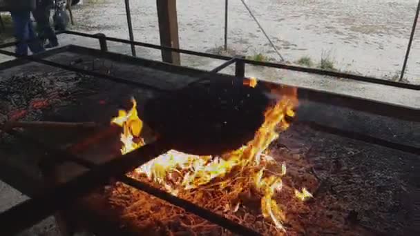 Châtaignes cuites avec une poêle caractéristique sur les flammes — Video