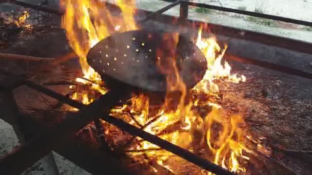 Kaštany vařené s charakteristickým pánvičem nad ohněm — Stock video