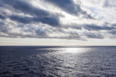 Güneş ışınları deniz üzerinde bulutlar aracılığıyla yansımaları oluşturan filtreleme