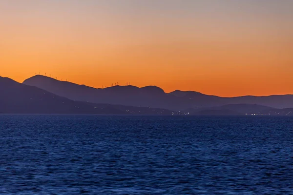 エーゲ海の島々のシルエットと日没時の風力タービン — ストック写真