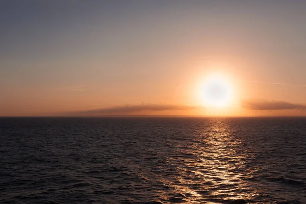 Sol a punto de ponerse detrás del horizonte en el mar con el fondo de la costa italiana — Foto de Stock