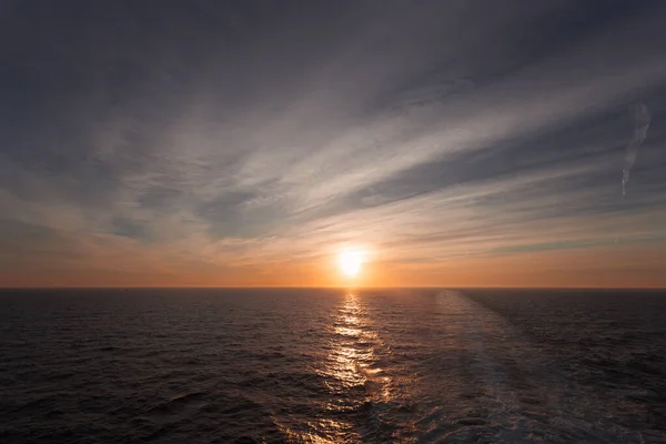 Reflejo de la puesta de sol de ensueño sobre el mar y despertar dejado por un crucero — Foto de Stock