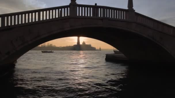 Vess egy pillantást a San Giorgio-szigeti híd boltozata alá naplementekor, Velencében. — Stock videók
