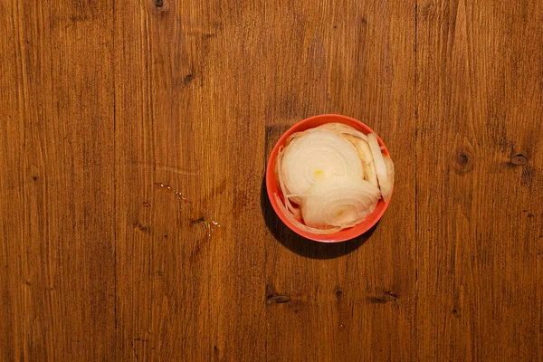 Top view of bowl full of onions on wooden background — Stock Photo, Image